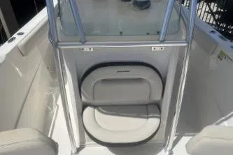 Slide: The Image of 2022 Sailfish 242 CC boat interior with cushioned seating and sleek design. - 10