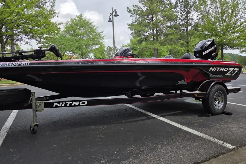The Image of 2011 Nitro Z-7 boat on trailer in parking lot, surrounded by trees. - 1