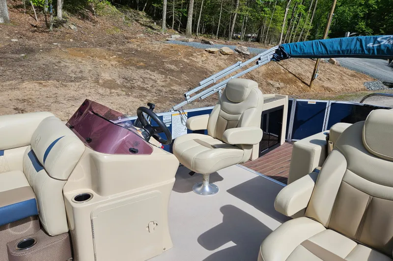 Slide: The Image of 2019 Sweetwater 2086 boat interior with beige seating and steering console. - 11