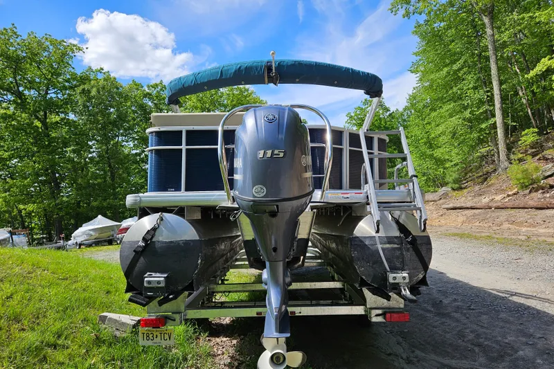 Slide: The Image of 2019 Sweetwater 2086 pontoon boat with Yamaha 115 engine, parked on a trailer in a wooded area. - 3