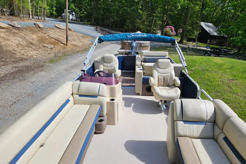 Slide: The Image of 2019 Sweetwater 2086 pontoon boat with beige seating, parked on a grassy area. - 7