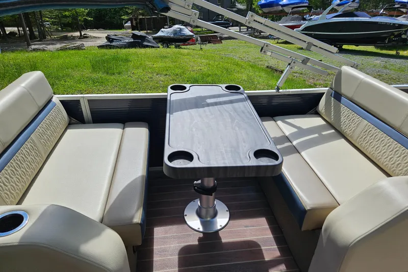 Slide: The Image of Interior of a 2019 Sweetwater 2086 pontoon boat with beige seating and a central table. - 8