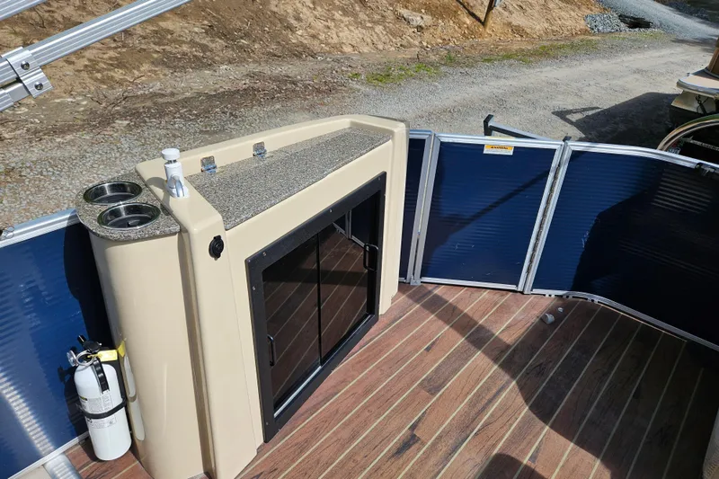 Slide: The Image of 2019 Sweetwater 2086 boat interior with storage cabinet and cup holders. - 9