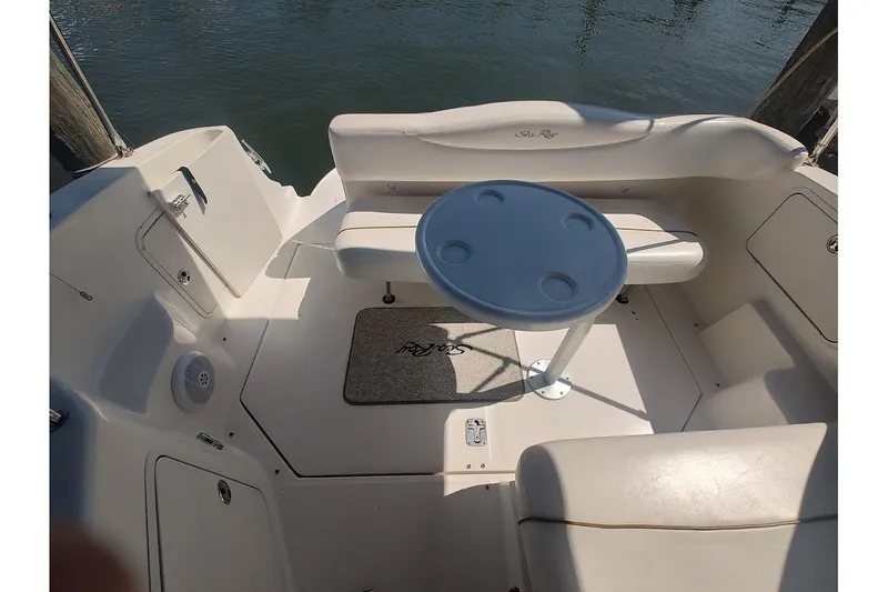 Slide: The Image of 2003 Sea Ray Sundancer 280 boat interior with seating and table on the water. - 10