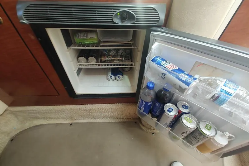 Slide: The Image of Mini fridge stocked with beverages inside a 2003 Sea Ray Sundancer 280 boat cabin. - 14