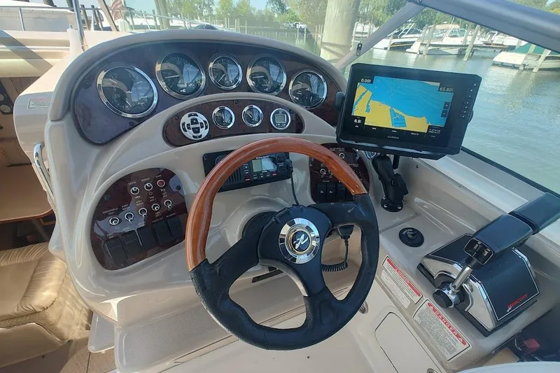 Slide: The Image of 2003 Sea Ray Sundancer 280 helm with steering wheel, gauges, and navigation display. - 19