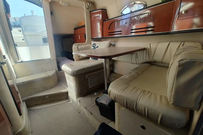 Slide: The Image of Interior of 2003 Sea Ray Sundancer 280 yacht with plush seating and wooden cabinetry. - 26