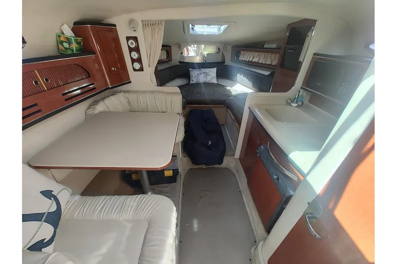 Slide: The Image of Interior of 2003 Sea Ray Sundancer 280, featuring cozy seating and compact kitchenette. - 28
