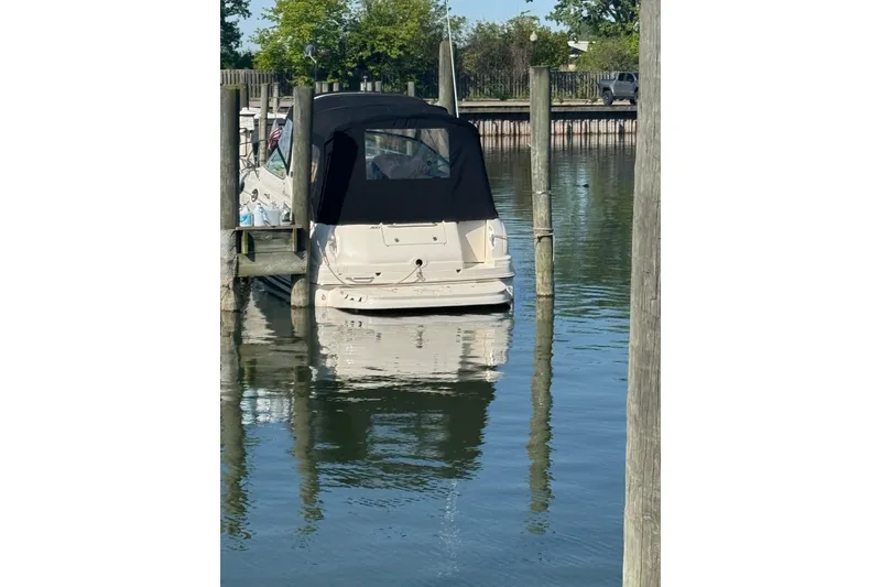 Slide: The Image of 2003 Sea Ray Sundancer 280 docked in calm waters, rear view with black canopy. - 45