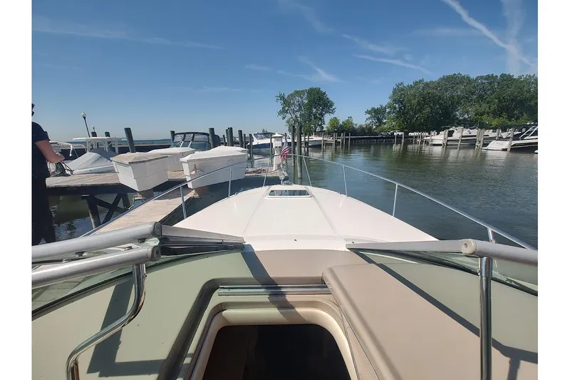 Slide: The Image of 2003 Sea Ray Sundancer 280 docked at marina, clear sky, calm water, trees in background. - 6