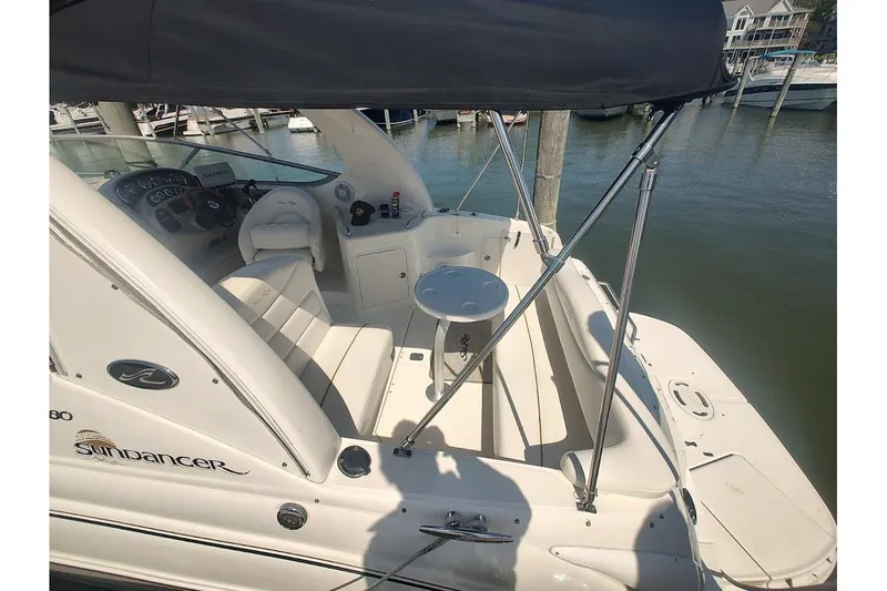 Slide: The Image of 2003 Sea Ray Sundancer 280 boat interior with seating and helm, docked at marina. - 7