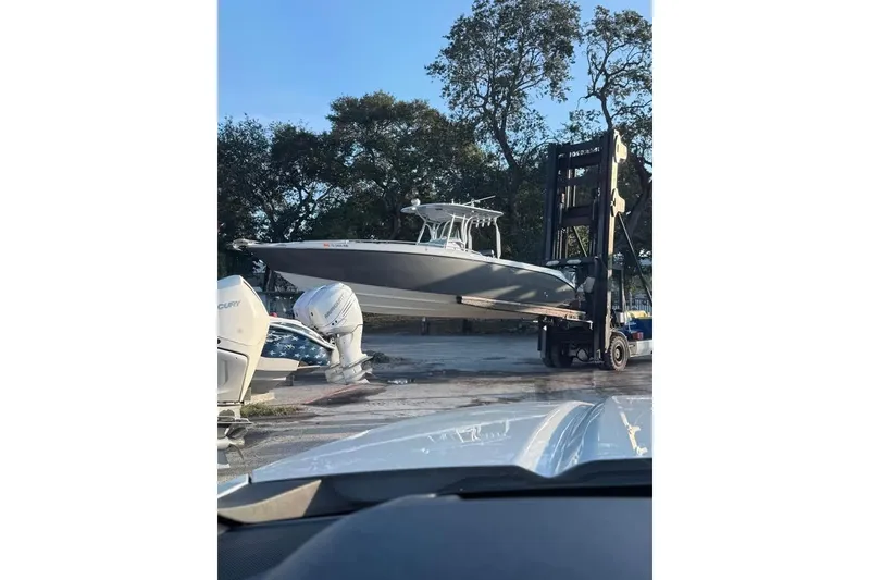 Slide: The Image of 2004 Baja 340 Sportfish boat lifted by forklift in outdoor setting. - 6