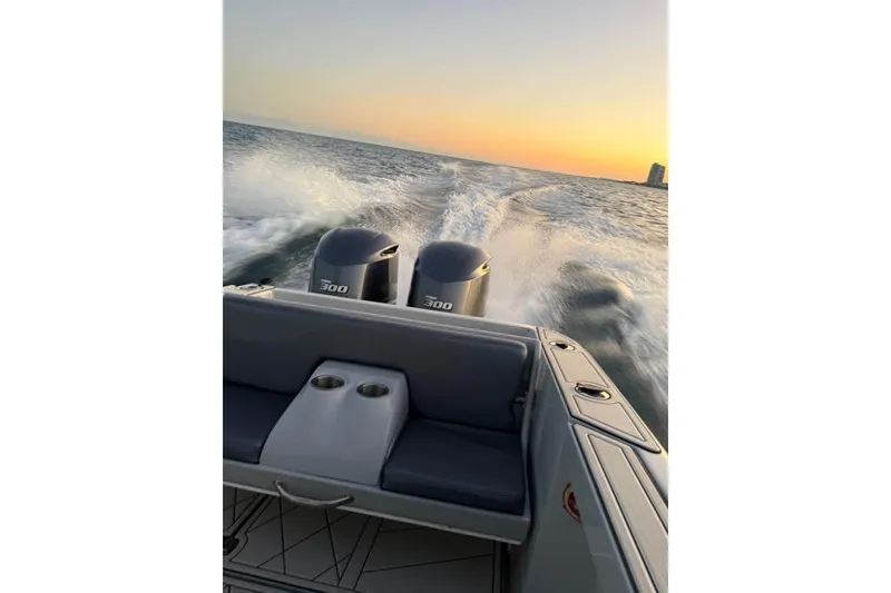 Slide: The Image of 2004 Baja 340 Sportfish speeding on ocean at sunset, twin engines visible. - 9