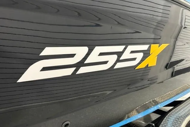 Slide: The Image of 2023 Yamaha Boats 255XE logo on sleek black hull. - 13