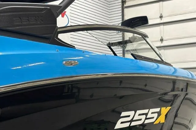 Slide: The Image of 2023 Yamaha Boats 255XE, sleek blue and black design, in a garage setting. - 14