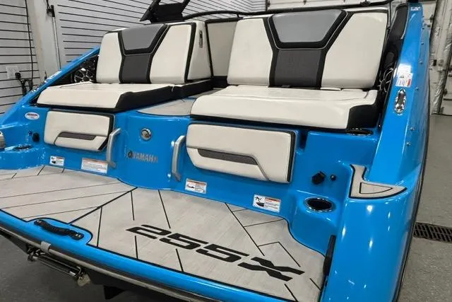 Slide: The Image of 2023 Yamaha Boats 255XE, blue exterior, luxury seating, modern design, rear view. - 18