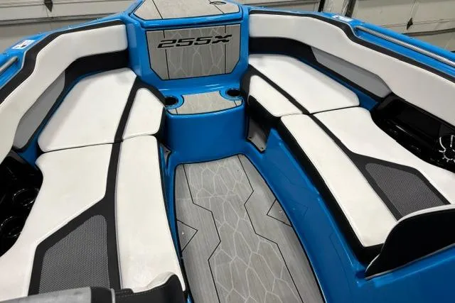 Slide: The Image of 2023 Yamaha Boats 255XE interior with blue and white seating, modern design, and spacious layout. - 20