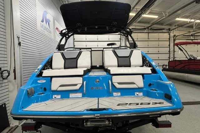Slide: The Image of 2023 Yamaha Boats 255XE in showroom, featuring sleek blue and white design. - 27