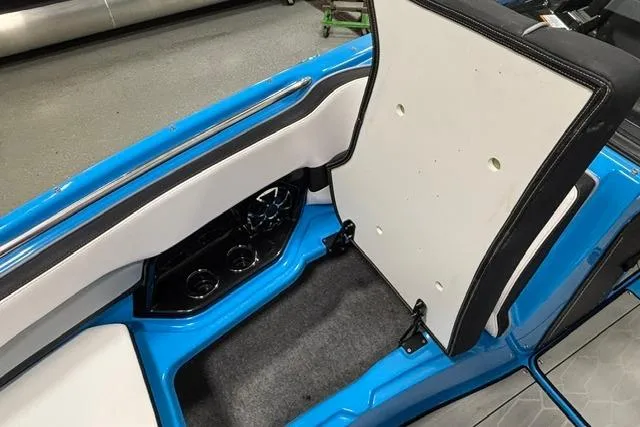 Slide: The Image of 2023 Yamaha Boats 255XE interior with blue accents and seating storage compartment. - 30