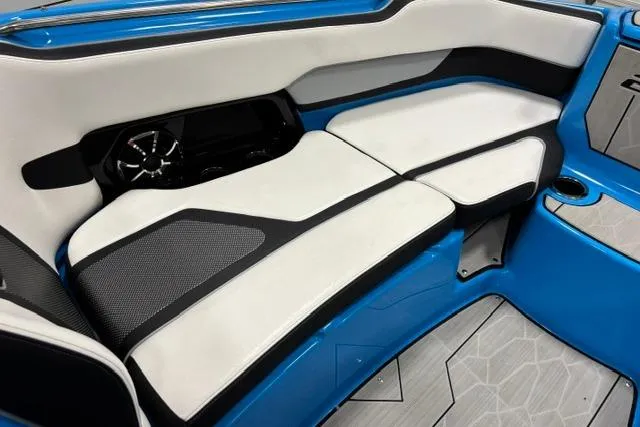 Slide: The Image of 2023 Yamaha Boats 255XE interior with sleek white and black seating, blue accents, and modern design. - 31