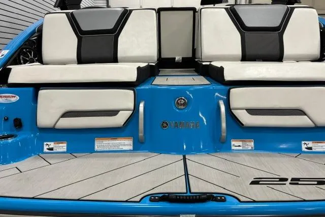 Slide: The Image of 2023 Yamaha Boats 255XE, sleek blue and white design, rear seating area. - 32