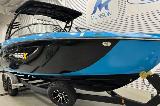 Slide: The Image of 2023 Yamaha Boats 255XE in showroom, blue and black design, on trailer. - 35