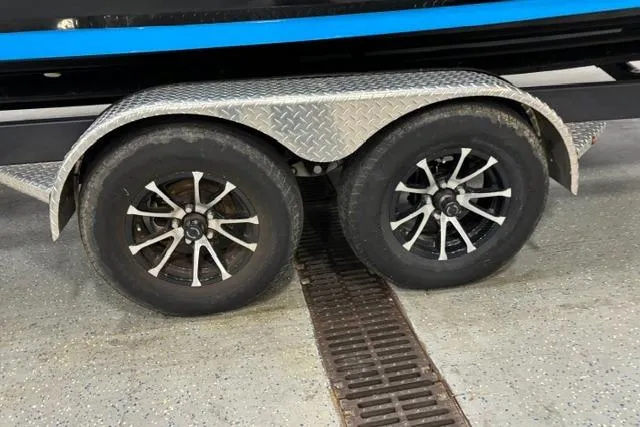 Slide: The Image of Trailer wheels of a 2023 Yamaha Boats 255XE on a diamond plate fender. - 36
