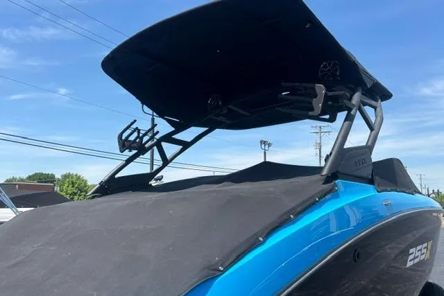 Slide: The Image of 2023 Yamaha Boats 255XE with sleek design and black canopy against a clear blue sky. - 37