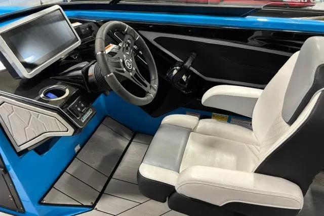 Slide: The Image of 2023 Yamaha Boats 255XE cockpit with modern steering, touchscreen, and comfortable seating. - 7