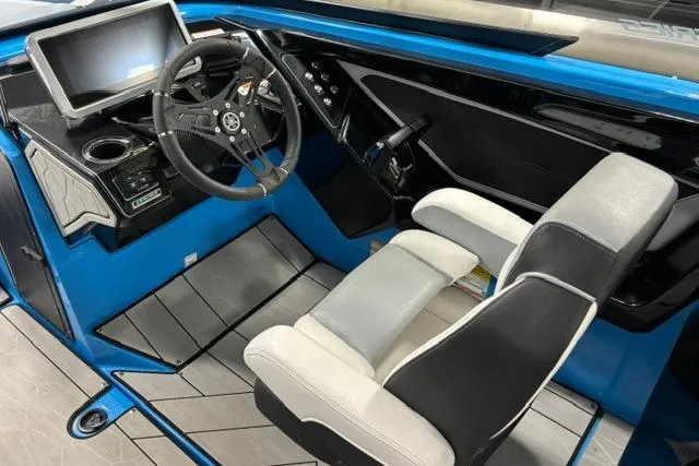 Slide: The Image of 2023 Yamaha Boats 255XE cockpit with modern steering, touchscreen, and comfortable seating. - 9