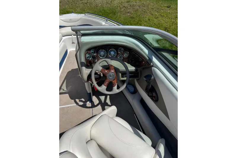 The Image of 2006 Crownline 21 Classic boat interior with steering wheel and dashboard controls. - 2
