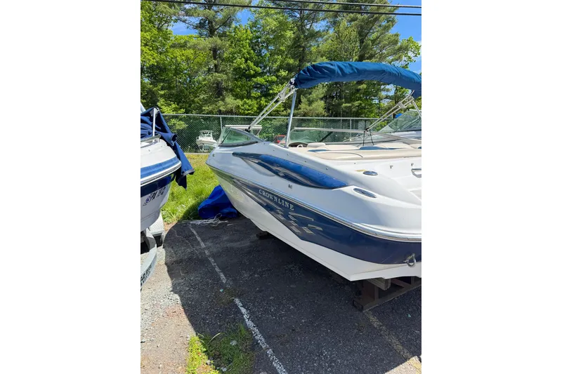 Slide: The Image of 2006 Crownline 21 Classic boat with blue canopy, parked outdoors. - 4