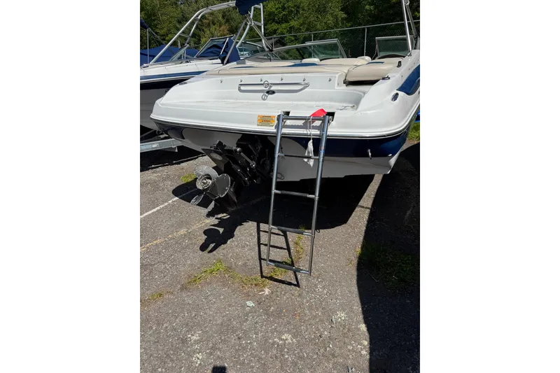 Slide: The Image of 2006 Crownline 21 Classic boat with ladder, parked on pavement. - 5