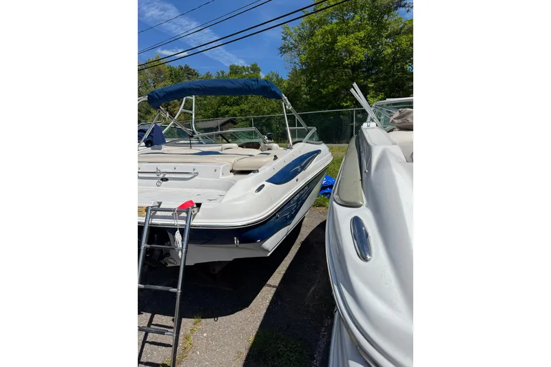 Slide: The Image of 2006 Crownline 21 Classic boat with blue canopy, parked outdoors. - 7