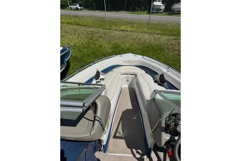 Slide: The Image of 2006 Crownline 21 Classic boat interior with seating and dashboard, parked on grass. - 9