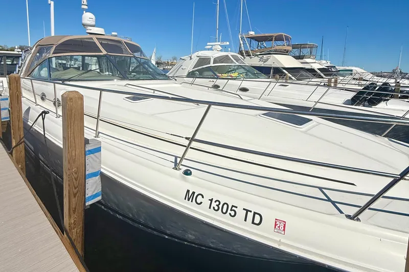 The Image of 2000 Sea Ray 410 Express Cruiser docked at marina under clear blue sky. - 0