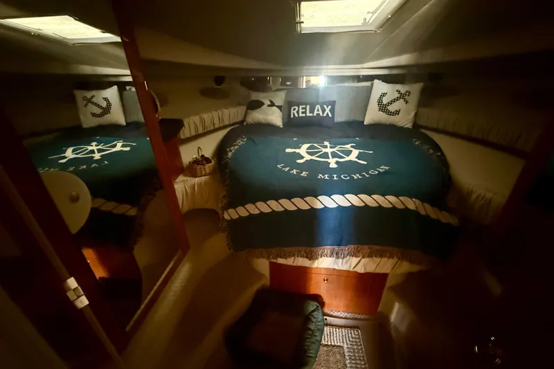 Slide: The Image of Cozy cabin interior of 2000 Sea Ray 410 Express Cruiser with nautical decor and "Lake Michigan" blanket. - 14