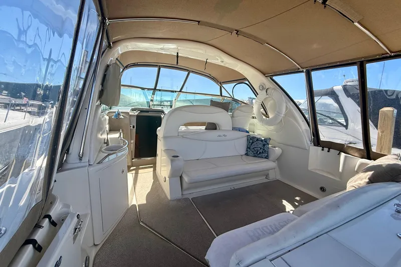 Slide: The Image of Interior of a 2000 Sea Ray 410 Express Cruiser with white seating and large windows. - 6