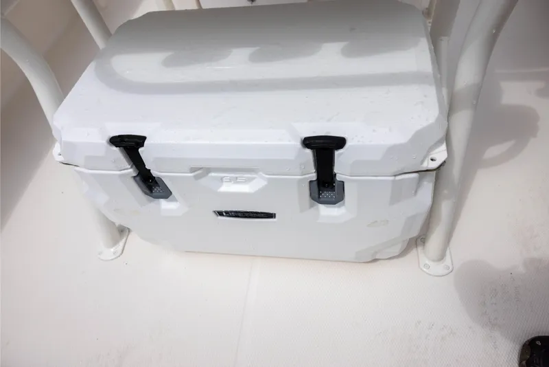 Slide: The Image of White cooler on 2015 Robalo 246 Cayman boat deck, secured with black latches. - 12