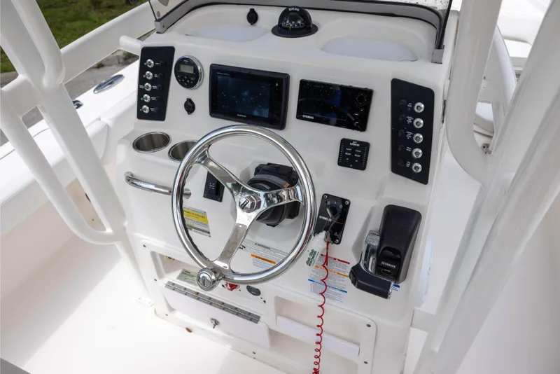 Slide: The Image of 2015 Robalo 246 Cayman boat dashboard with steering wheel and navigation controls. - 13