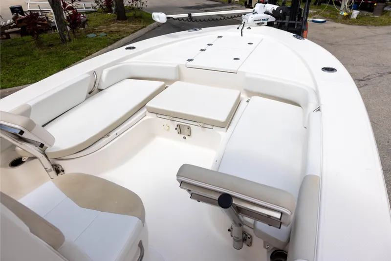 Slide: The Image of 2015 Robalo 246 Cayman boat interior with white seating and storage compartments. - 15