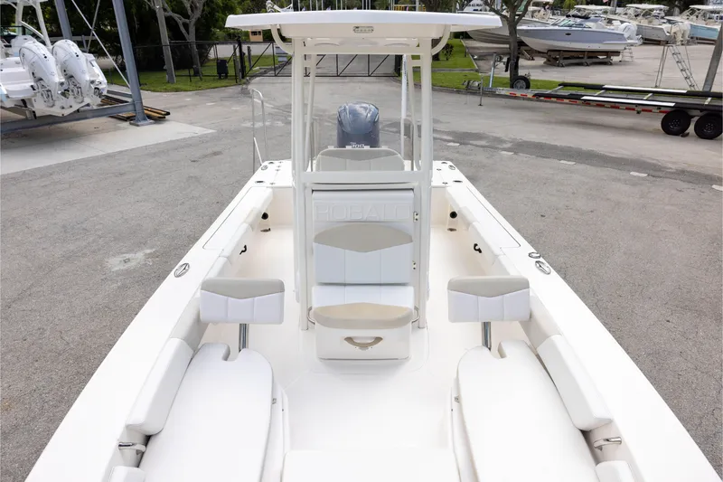 Slide: The Image of 2015 Robalo 246 Cayman boat interior with seating and console, parked in a marina. - 18