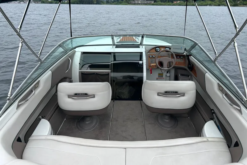 Slide: The Image of 1995 Cobalt 253 boat interior with steering wheel, seats, and lake view. - 13