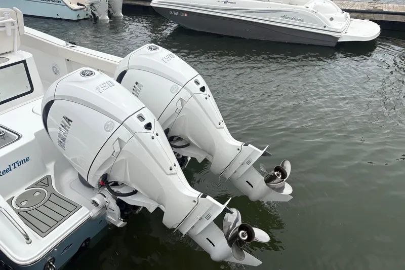 Slide: The Image of Twin Yamaha outboard engines on a 2025 Sea Hunt Gamefish 25 boat at a marina. - 11
