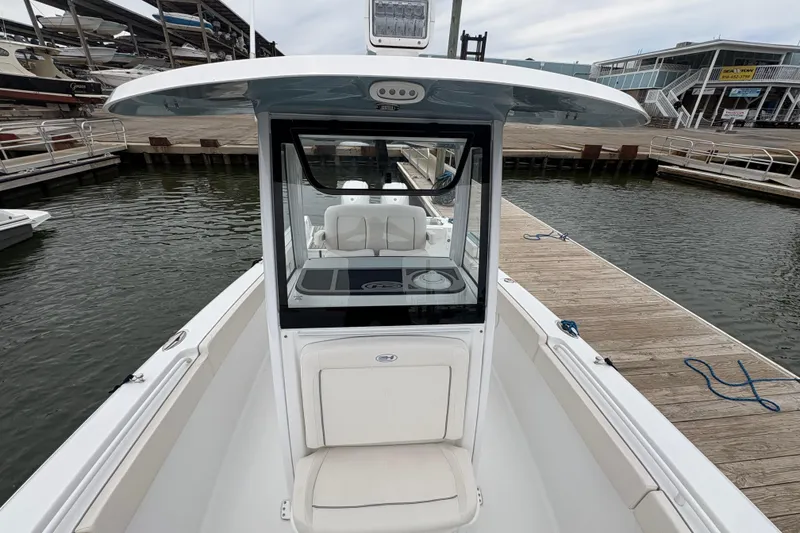 Slide: The Image of 2025 Sea Hunt Gamefish 25 boat docked at marina, showcasing helm and seating area. - 14