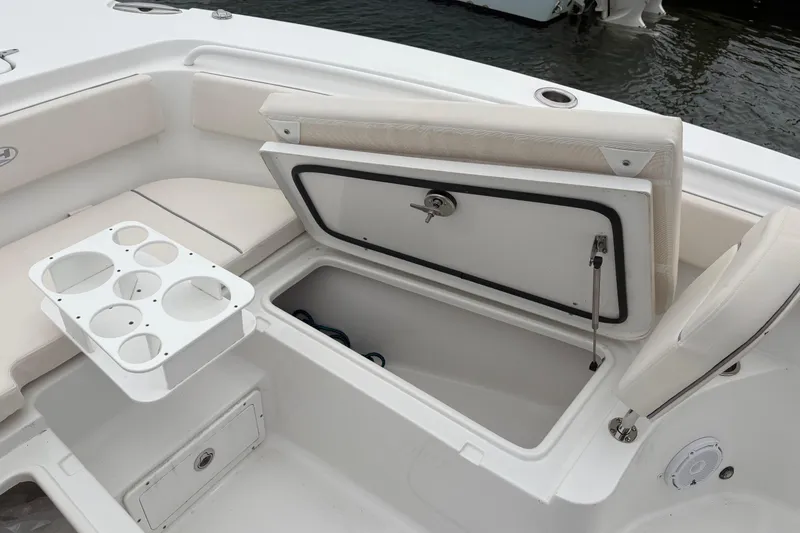 Slide: The Image of 2025 Sea Hunt Gamefish 25 boat interior with open storage compartment and cup holders. - 19