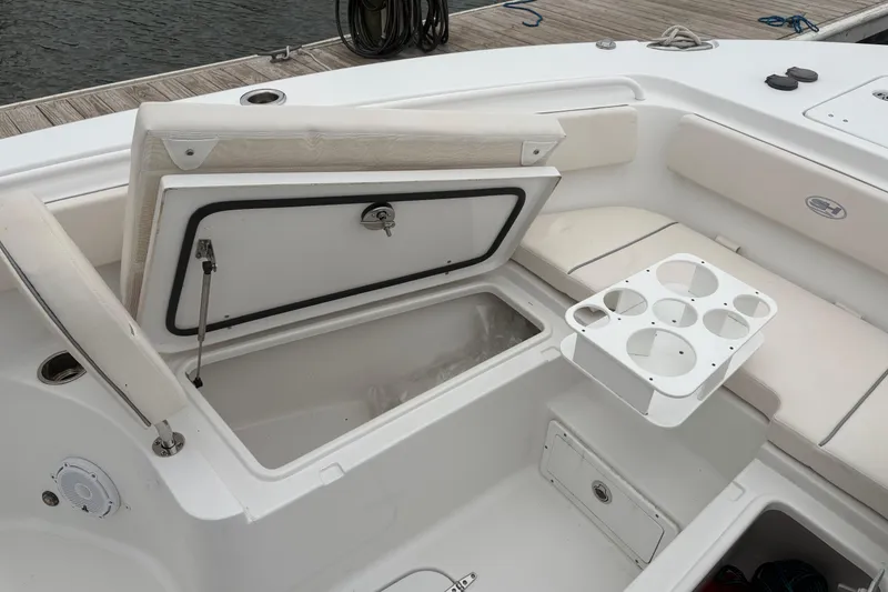 Slide: The Image of 2025 Sea Hunt Gamefish 25 boat interior with open storage compartment and cup holders. - 20