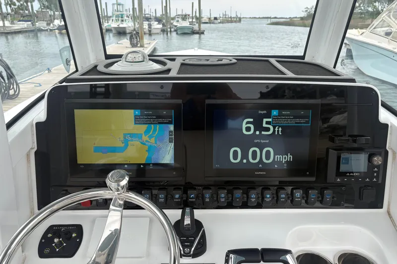 Slide: The Image of Dashboard of 2025 Sea Hunt Gamefish 25 with navigation and depth displays. - 26