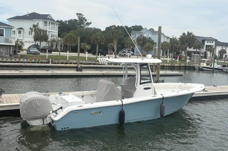 Slide: The Image of 2025 Sea Hunt Gamefish 25 boat docked at a marina with waterfront homes in the background. - 3