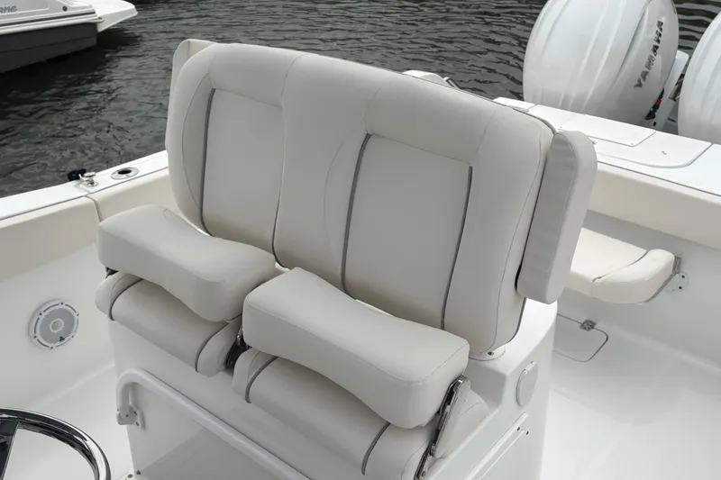 Slide: The Image of 2025 Sea Hunt Gamefish 25 boat seating with cushioned armrests, on calm water. - 35